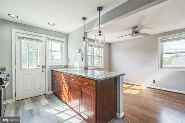 a kitchen with a stove a sink and wooden floor
