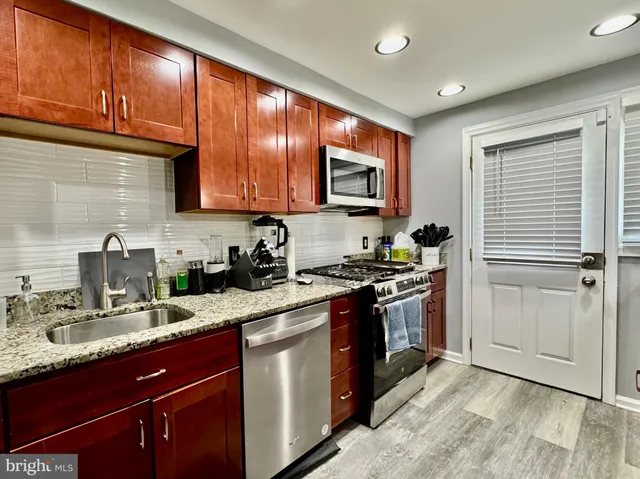 a kitchen with stainless steel appliances granite countertop a stove sink and cabinets