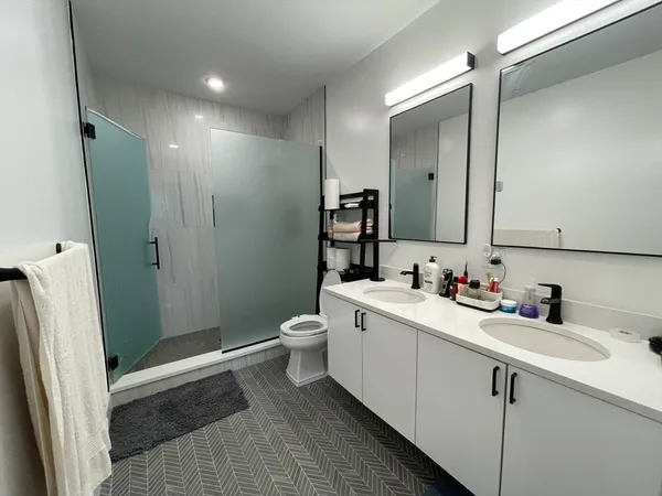 a bathroom with a sink a toilet and shower