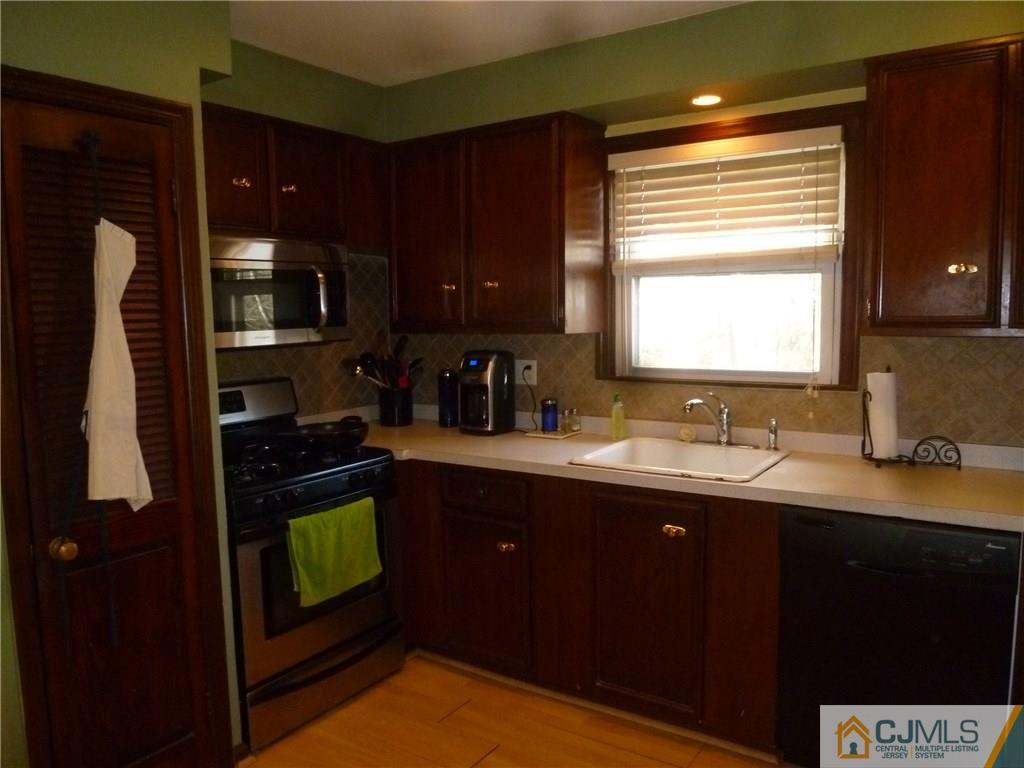 108 Kimberly Road Colonia, NJ 07067 - Photo 6 of 14 a kitchen with a sink cabinets and a window