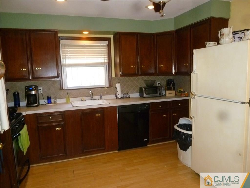 108 Kimberly Road Colonia, NJ 07067 - Photo 7 of 14 a kitchen with a sink a refrigerator and cabinets