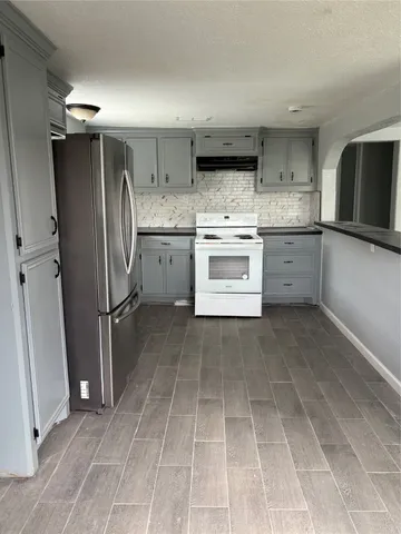 a kitchen with stainless steel appliances granite countertop a refrigerator sink and stove