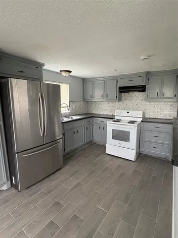a view of a kitchen with a refrigerator and a microwave