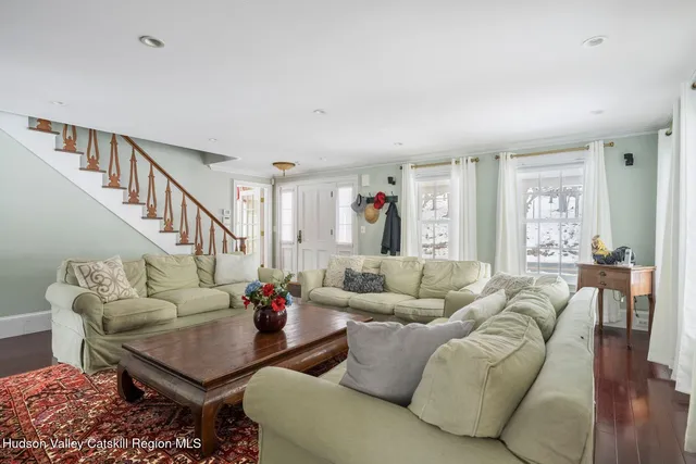 a kitchen with a sink dishwasher a stove a microwave oven and a dining table with wooden floor