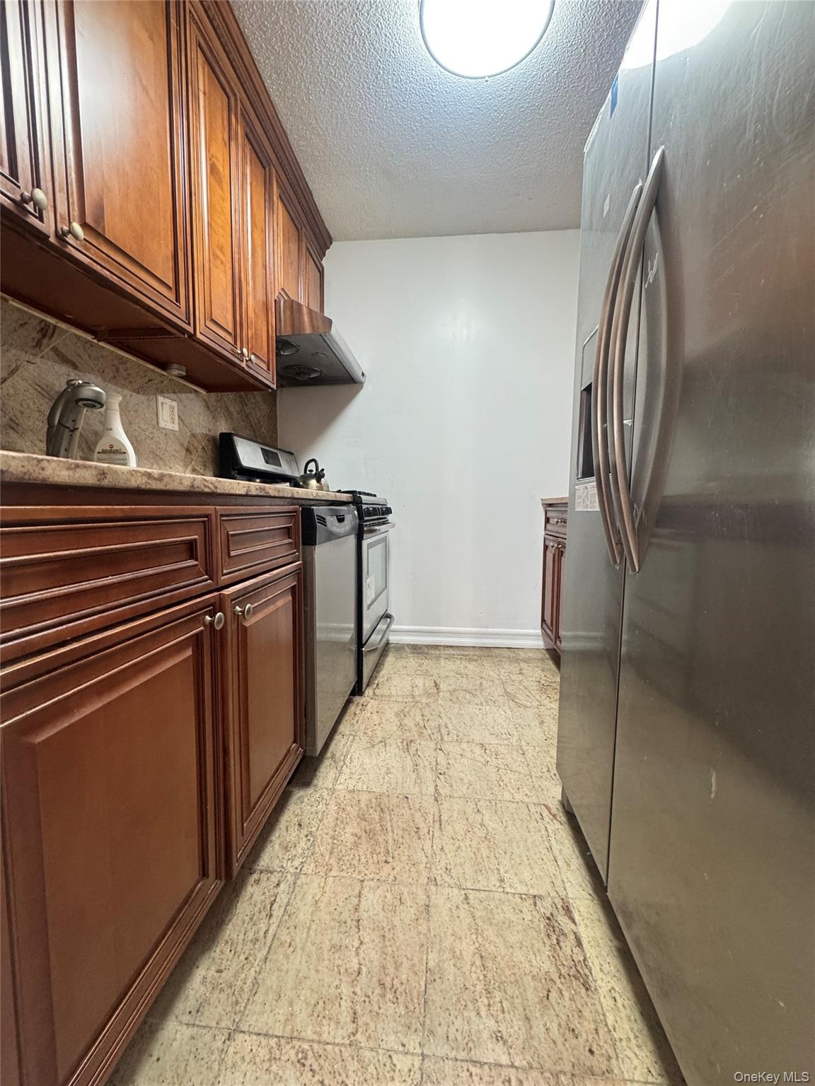 41-40 Union Street, Unit 16D Queens, NY 11355 - Photo 5 of 12 a kitchen with stainless steel appliances granite countertop a stove and a sink