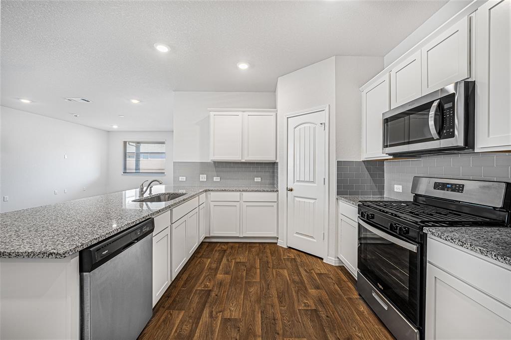 121 Mackinac Lane Georgetown, TX 78626 - Photo 2 of 16 a kitchen with stainless steel appliances granite countertop a stove a sink and a microwave