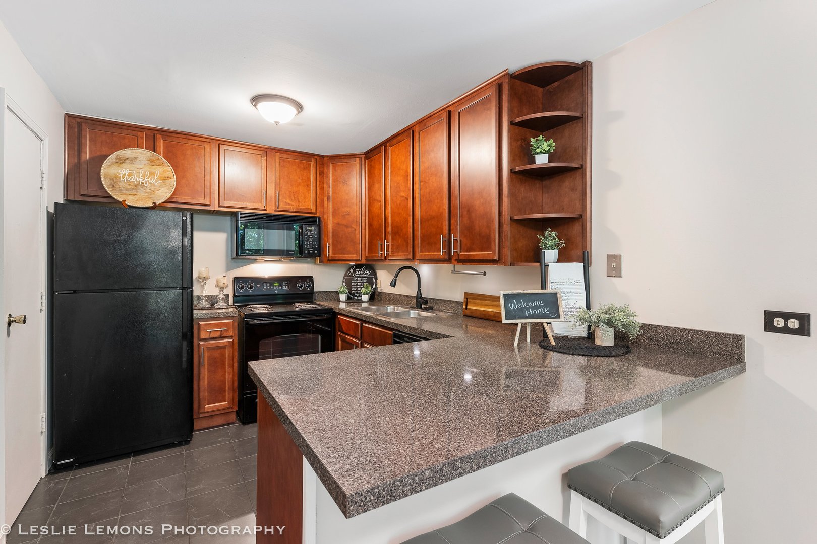 5902 Forest View Road, Unit 1C Lisle, IL 60532 - Photo 10 of 34 a kitchen with stainless steel appliances granite countertop a refrigerator a stove and a sink with wooden cabinets
