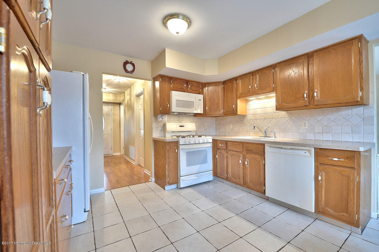 90 Starlight Road Howell, NJ 07731 - Photo 14 of 40 a kitchen with a refrigerator sink and cabinets