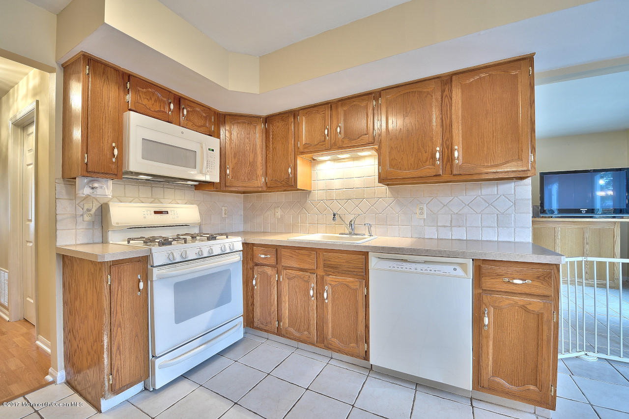 90 Starlight Road Howell, NJ 07731 - Photo 18 of 40 a kitchen with stainless steel appliances granite countertop a sink stove and cabinets