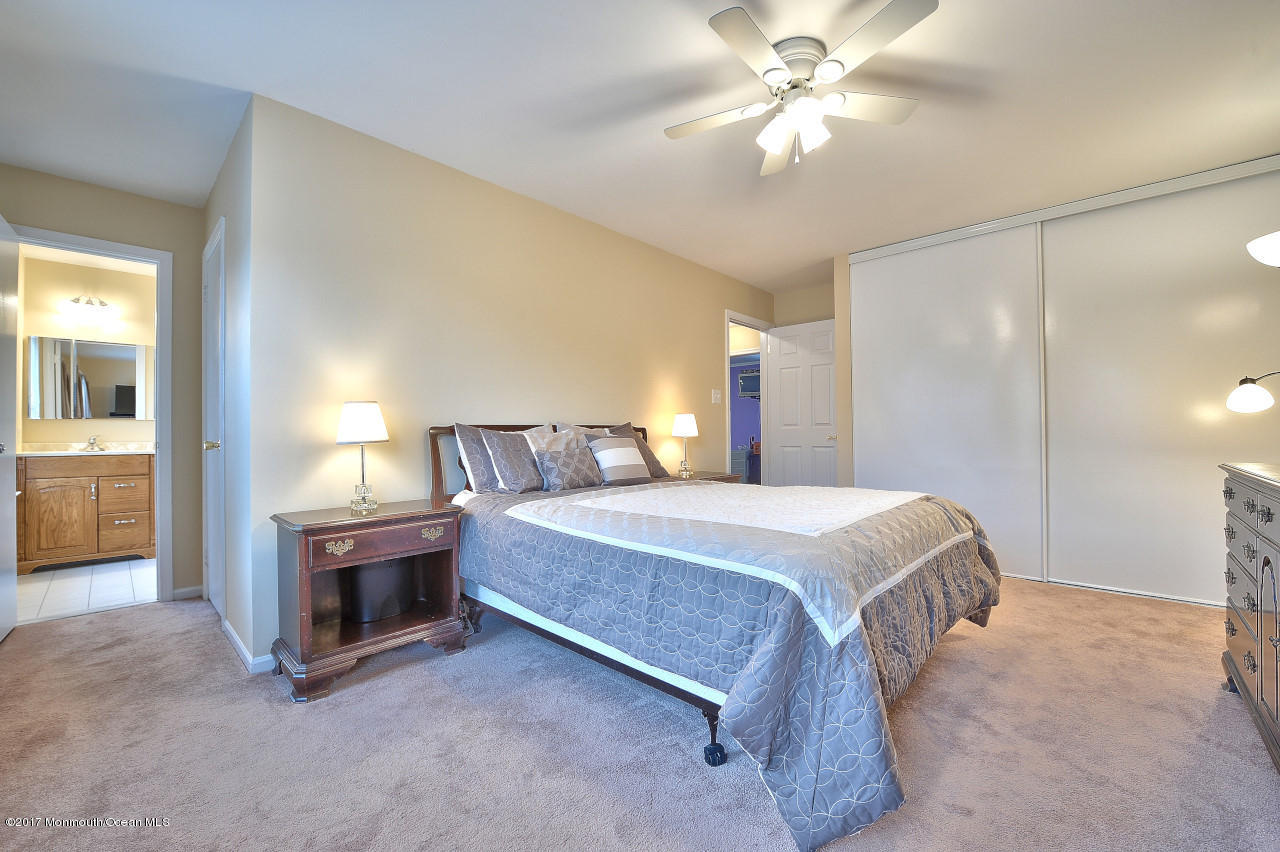 90 Starlight Road Howell, NJ 07731 - Photo 26 of 40 a spacious bedroom with a bed and a chandelier