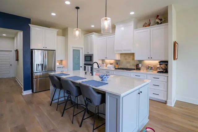 a kitchen with a table chairs refrigerator and microwave