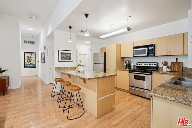 a kitchen with granite countertop a table chairs microwave and cabinets
