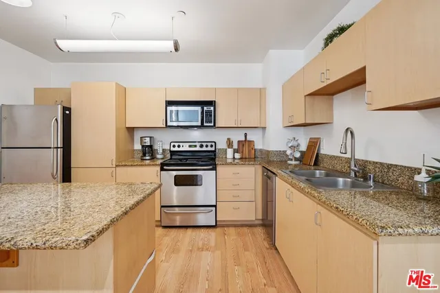 a kitchen with granite countertop a sink stove and refrigerator