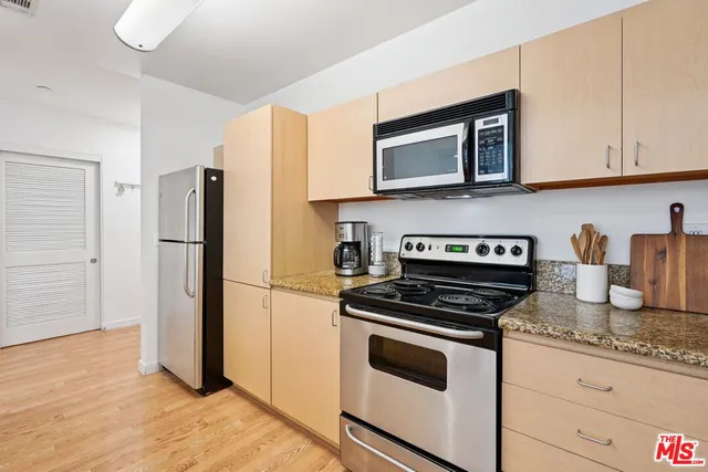 a kitchen with granite countertop a refrigerator stove and microwave