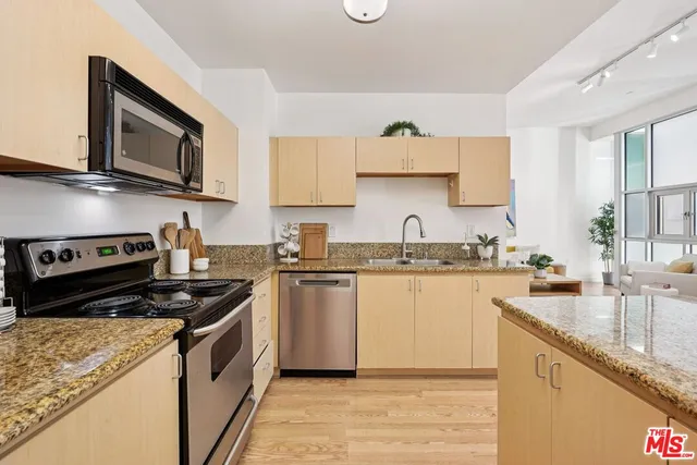 a kitchen with stainless steel appliances granite countertop a sink stove and microwave