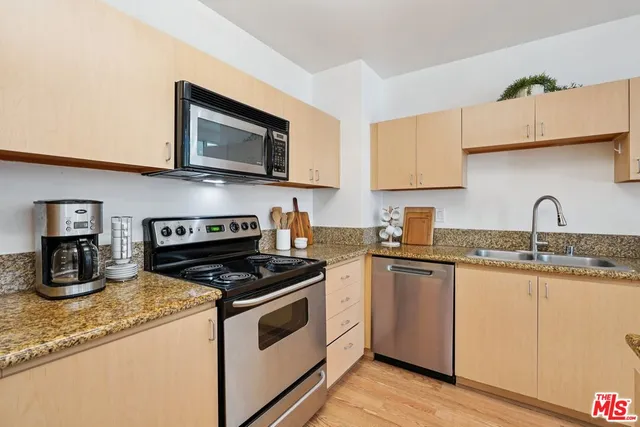 a kitchen with granite countertop a sink and a stove top oven