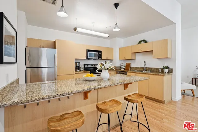 a kitchen with stainless steel appliances granite countertop a sink refrigerator and cabinets