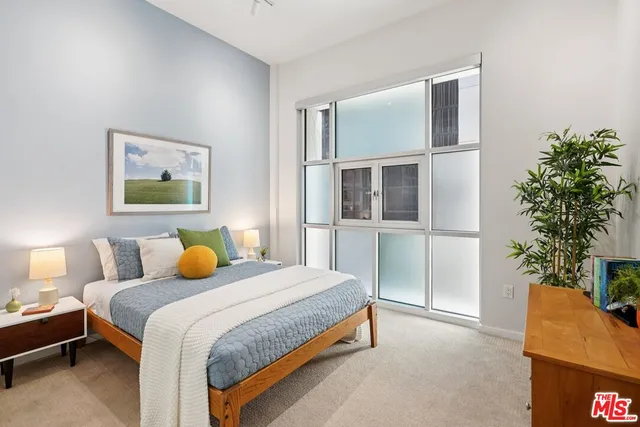 a bedroom with a bed and a potted plant