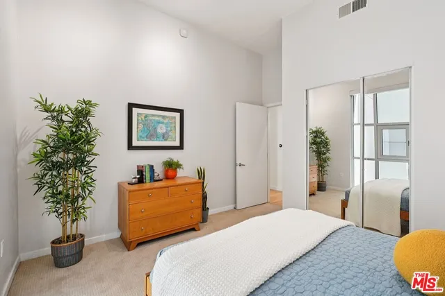 a bedroom with a bed and a potted plant