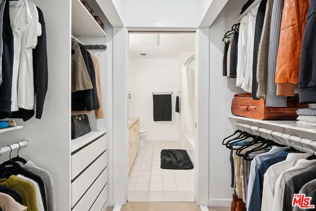 a view of walk in closet with clothes and shoes