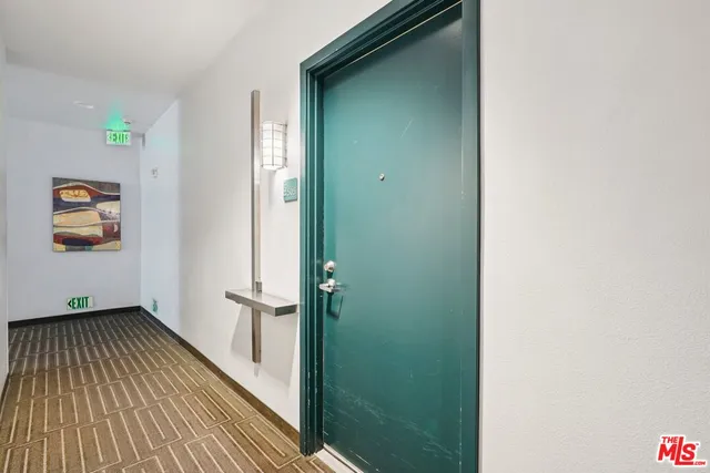 a view of a hallway with wooden floor and a bathroom