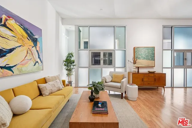 a living room with furniture fireplace and a large window