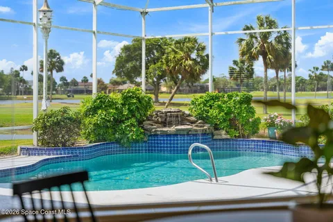 a view of a swimming pool with a garden and trees