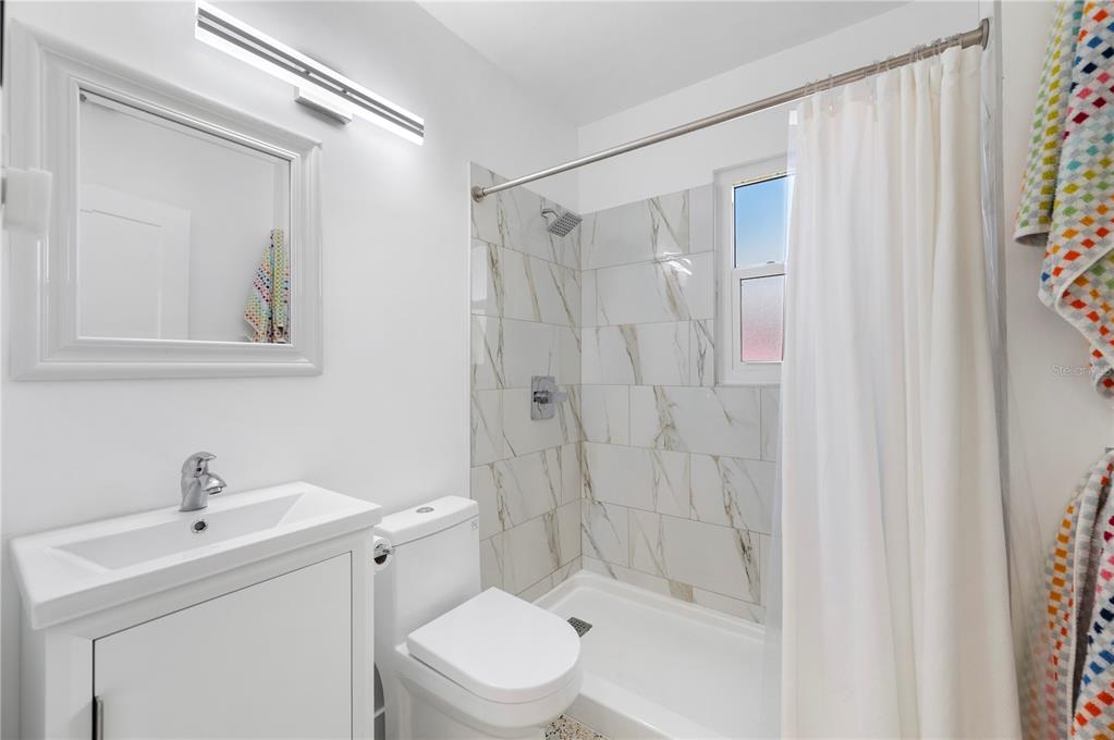 624 West Virginia Avenue Punta Gorda, FL 33950 - Photo 28 of 45 a bathroom with a shower a sink and a mirror