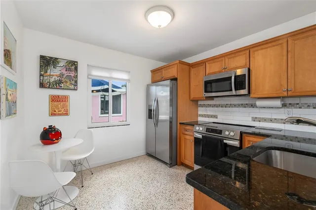 a kitchen with stainless steel appliances cabinets and wooden floor