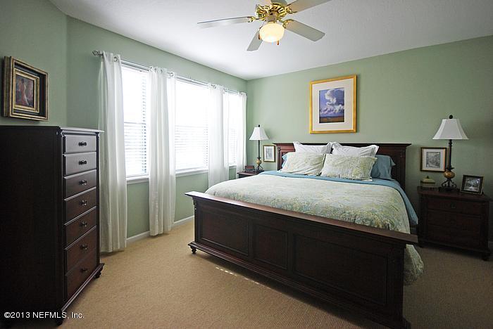 3117 Haley Pointe Road, Unit 3117 St. Augustine, FL 32084 - Photo 7 of 23 a bedroom with a bed and a chandelier