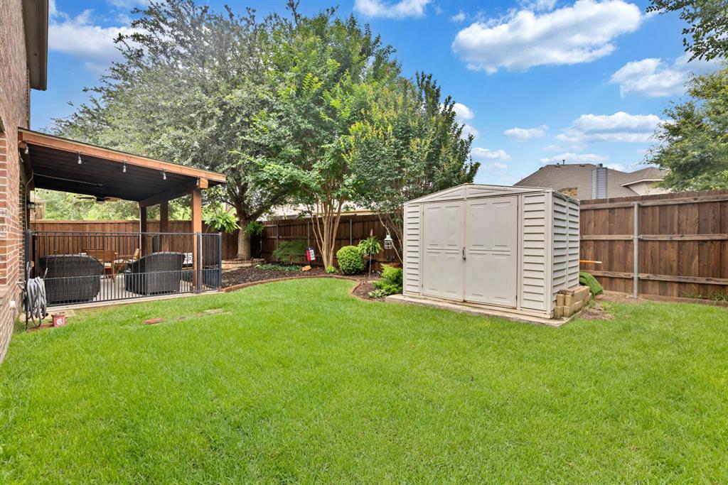 1701 Meadow Ranch Road McKinney, TX 75071 - Photo 33 of 40 a view of a backyard with a garden and trees