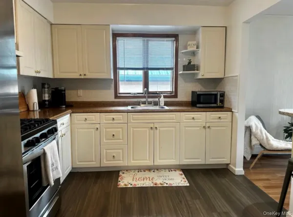 a kitchen with stainless steel appliances a stove a sink and white cabinets