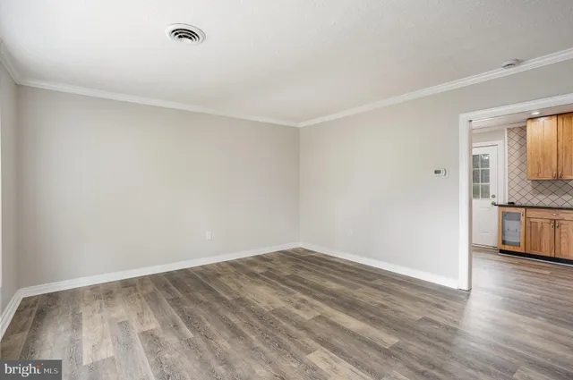 a view of empty room with wooden floor and electronic appliances