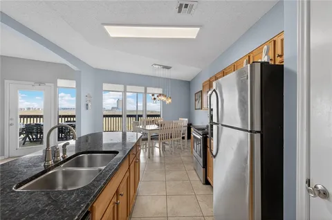 a kitchen with refrigerator a sink and chairs