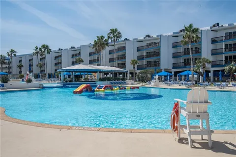 a swimming pool with outdoor seating and yard in the back
