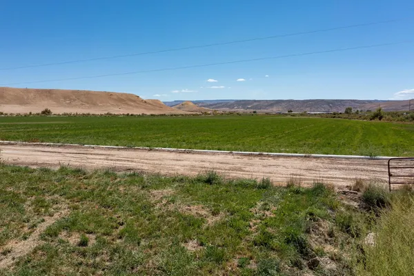 a view of a green field with mountains in the background