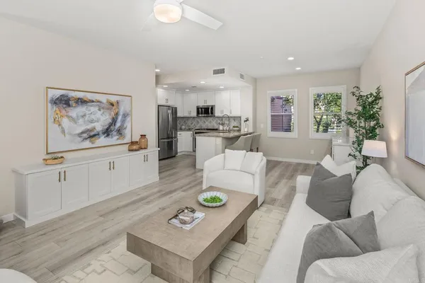 a living room with furniture and view of kitchen