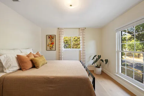 a bedroom with a bed and a large window