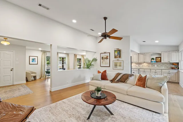 a living room with furniture a rug and kitchen view