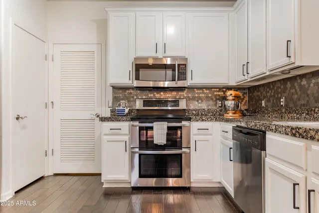 a kitchen with stainless steel appliances granite countertop a stove and a refrigerator