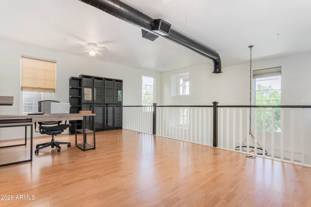 a view of a livingroom with furniture wooden floor and windows