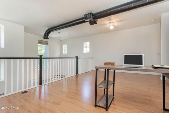 a view of a hallway with wooden floor and windows