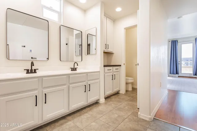 a spacious bathroom with double sink and a mirror