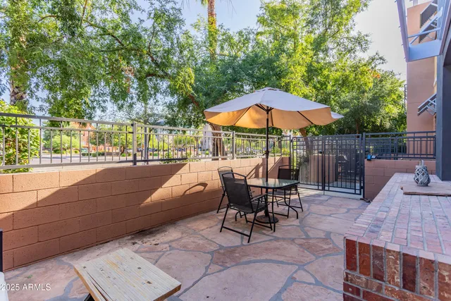 a view of a patio with a table and chairs under an umbrella