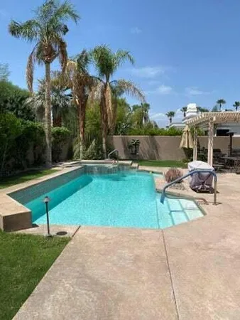 a view of a backyard with swimming pool