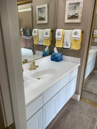 a bathroom with a sink a mirror and a picture on the wall