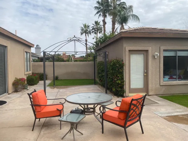 a backyard of a house with table and chairs