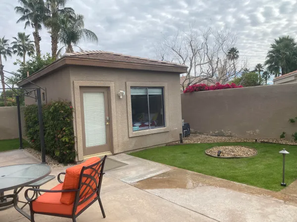 a backyard of a house with table and chairs