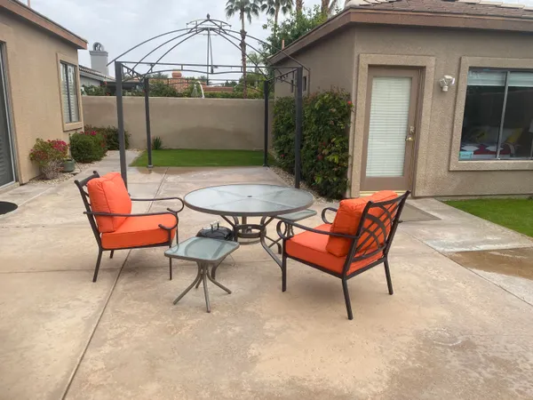 a backyard of a house with table and chairs