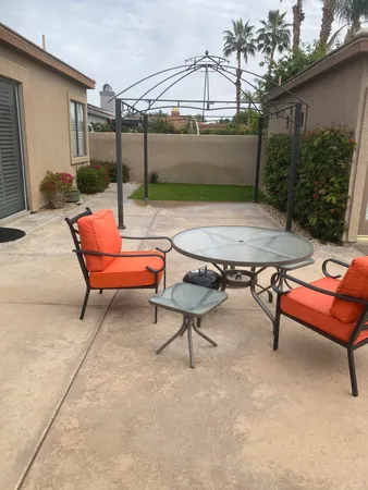 a backyard of a house with table and chairs